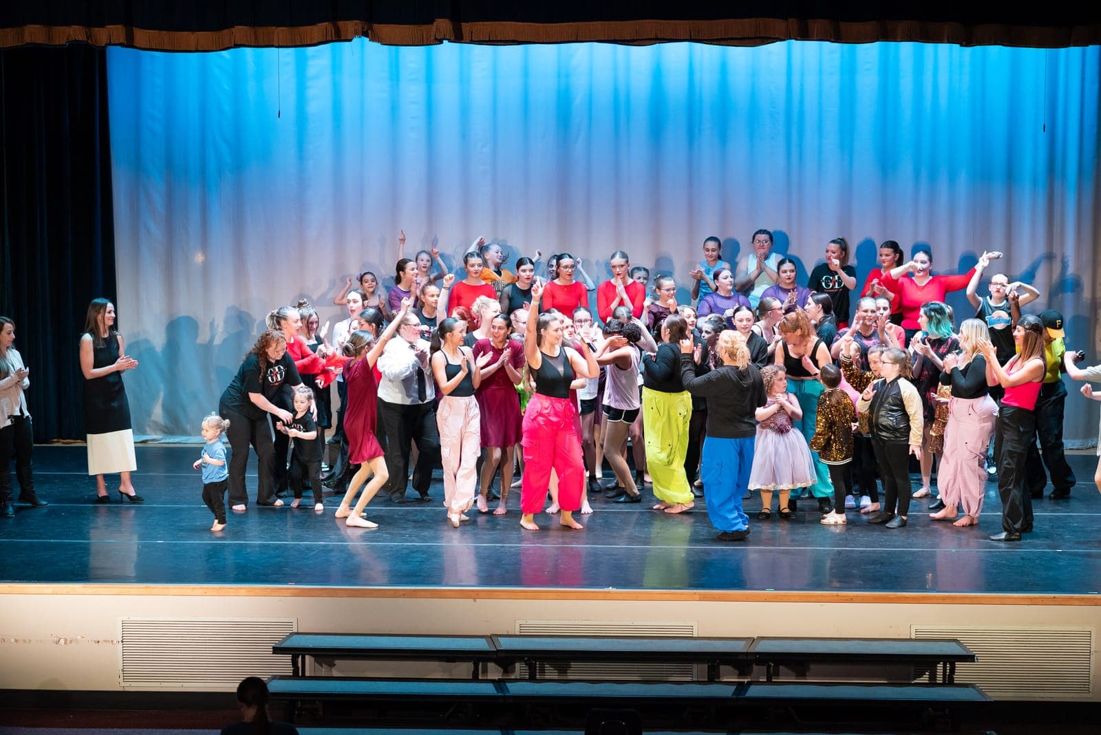 The full cast of Gotta Dance performers celebrating together on stage at the recital finale